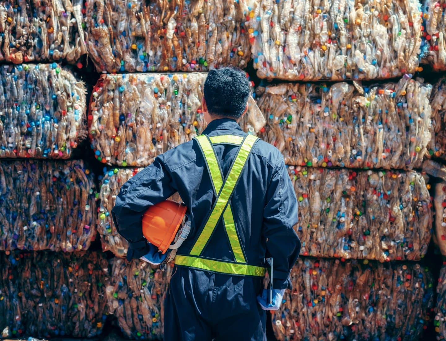 Operador frente a pacas de plástico reciclable