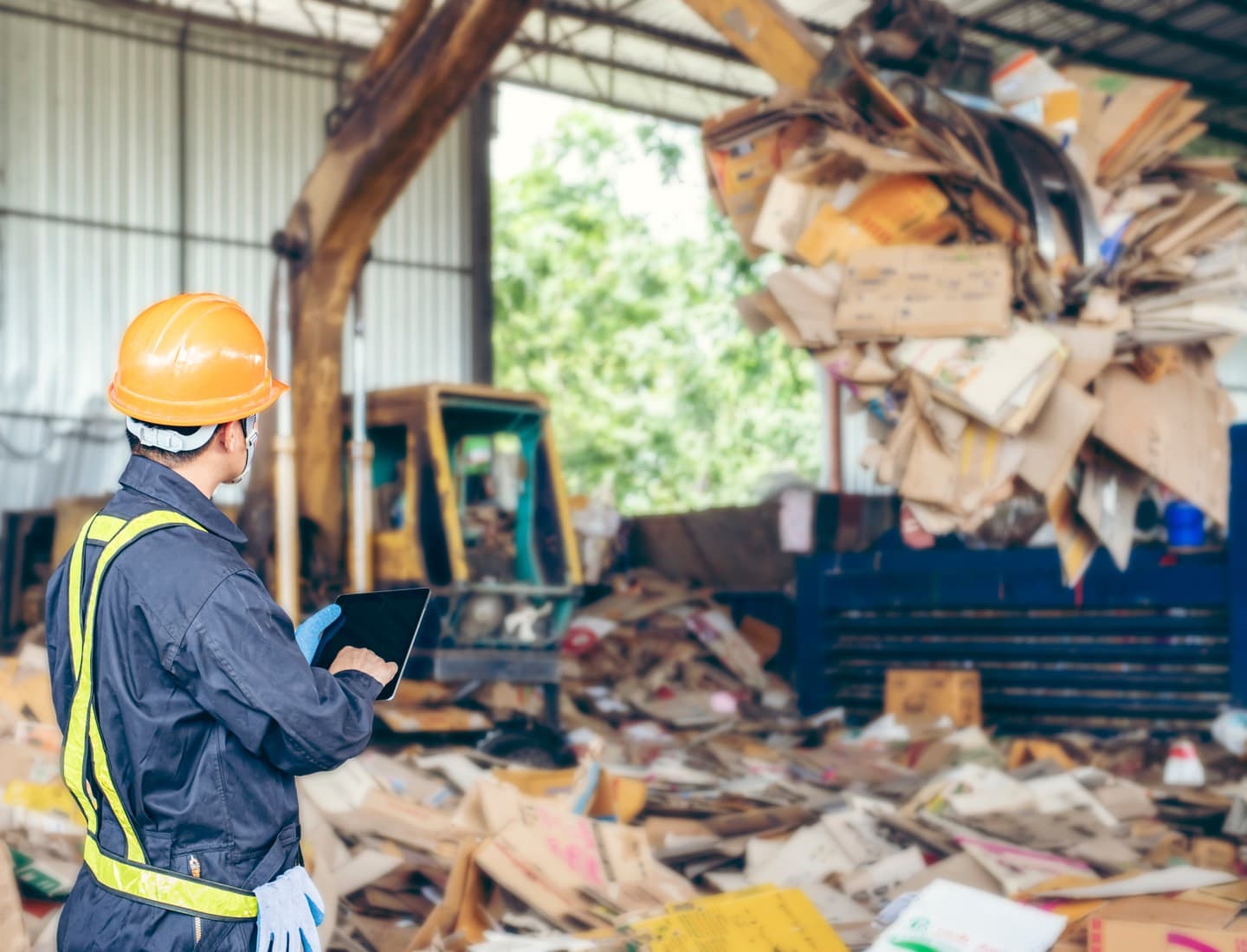 Supervisor revisando inventario en planta de reciclaje de papel y cartón
